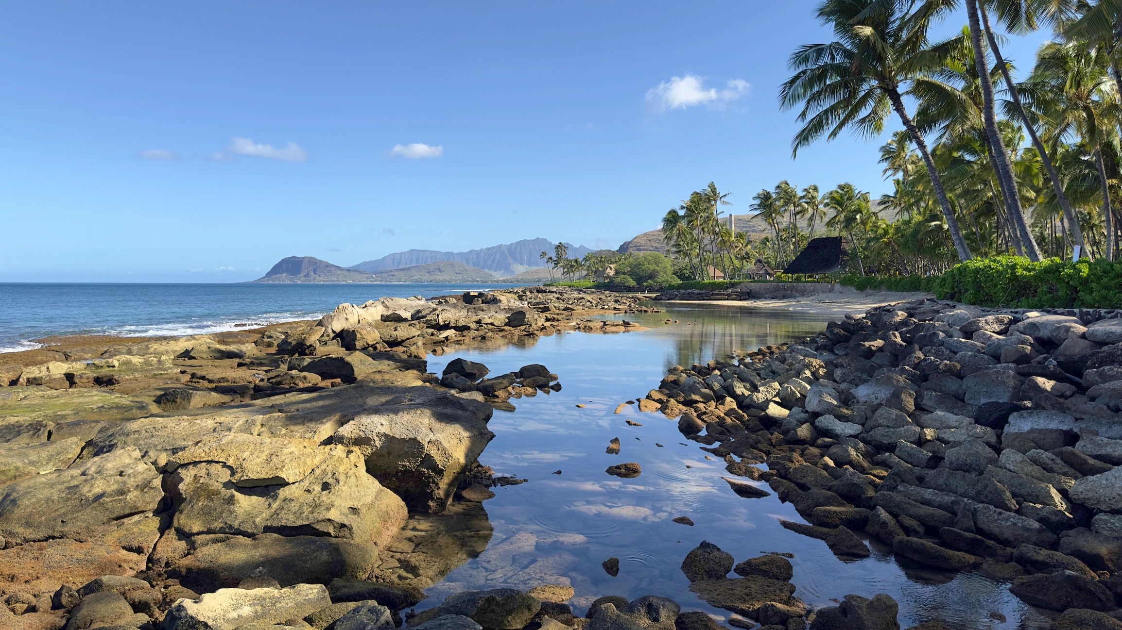 Ko Olina coastline on Oahu with mountain ridge and beach