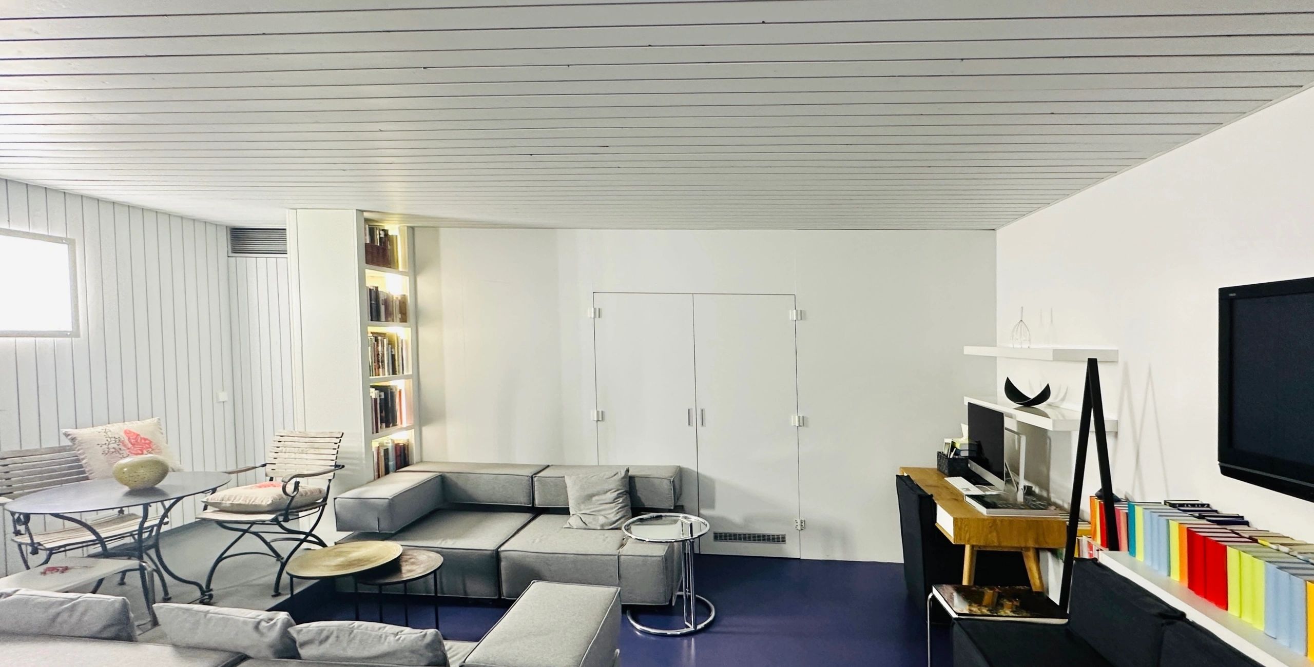 Home office with sofa landscape and desk, wide shot