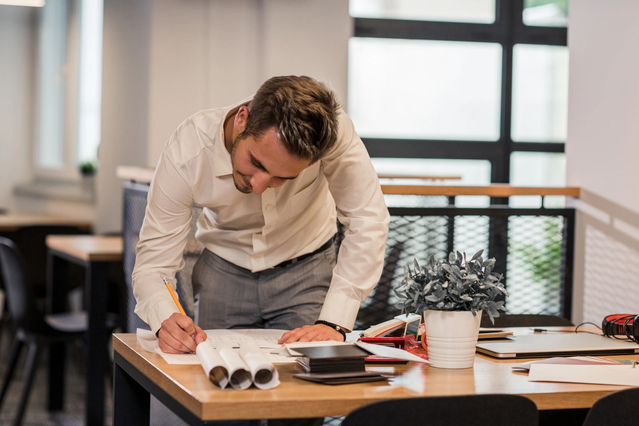 Architect reviewing blueprints laid out on a desk